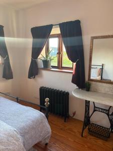 a bedroom with a bed and a mirror and a window at THE FARMHOUSE Room 1 in Balcunnin