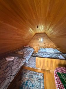 a room with two beds in a wooden cabin at Planinska Koliba Mo in Katun Božički