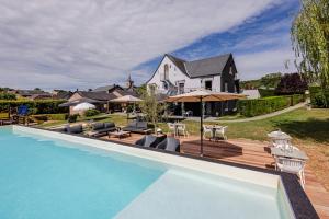 a house with a swimming pool in front of a house at Hotel & Restaurant Maison Pal'Ange in Durbuy
