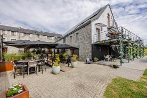 a patio with tables and chairs and umbrellas at Hotel & Restaurant Maison Pal'Ange in Durbuy