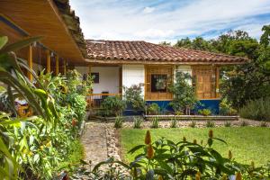 ein Haus mit Garten davor in der Unterkunft El Laurel Finca Agroturistica in Quimbaya