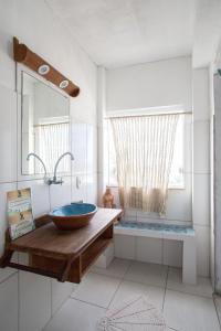 uma casa de banho com um lavatório de madeira e um espelho em Alfazema Cultural Bed and Breakfast em Arembepe