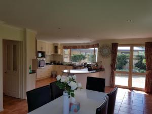 a kitchen with a table with a vase of flowers on it at Makepeace Place Homestay in Hamilton