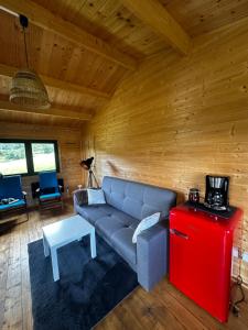 a living room with a couch and a red refrigerator at Srebrny Domek in Ostroszowice