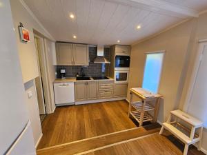 a kitchen with white appliances and wooden floors at Sandmo Holiday Home 13 in Eckerö