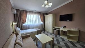 a hotel room with a couch and a bed and a desk at Panorama 7 day's in Hacıselli +21 photos