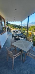 a patio with tables and chairs on a balcony at Vila Nakaj Guest House in Gjirokastër