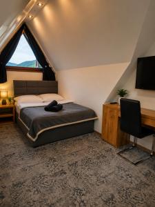 a bedroom with a bed and a desk and a television at SKALNA CHATA 150 m do Term, Basen in Białka Tatrzańska +45 photos