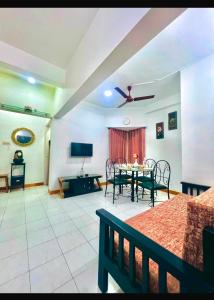a living room with a table and chairs and a tv at Serene Guest House ll 2 Ac Rooms ll WiFi ll Tv ll Big Garden in Lonavala