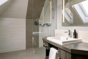 a bathroom with a sink and a shower at HENRI Hotel Garmisch-Partenkirchen in Garmisch-Partenkirchen +116 photos