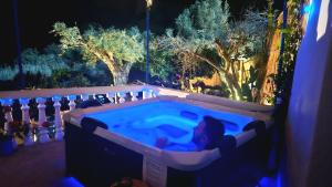 a hot tub with a teddy bear in it at night at Aegean Serenity - Sea View Retreat in Archangelos