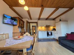 a kitchen and living room with a table and a couch at Orterhof in Obertilliach