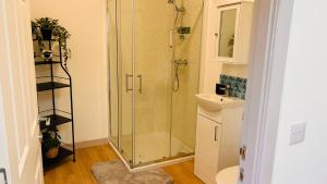 a bathroom with a glass shower and a sink at Bathach Mor in Oban +18 photos