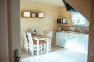 a kitchen with a table and chairs in a room at Domki Pod Lasem Lubkowo in Lubkowo