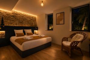 a bedroom with a large bed and two chairs at Gite De La Borie in Saint-Ignat