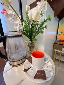a table with a vase of flowers and a coffee cup at Zensean Haven in General Santos +1 photo