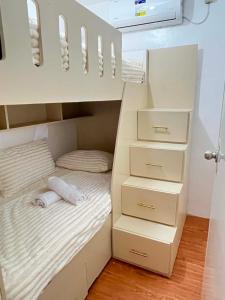 a bedroom with a bunk bed with white drawers at Zensean Haven in General Santos