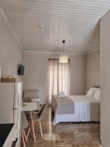 a bedroom with a bed and a desk and a television at Arco Boutique Apartments in Paralio Astros