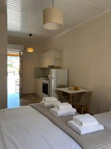 a room with a bed and a kitchen with a table at Arco Boutique Apartments in Paralio Astros