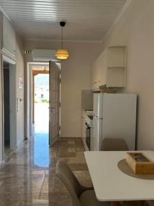 a kitchen with a white table and a refrigerator at Arco Boutique Apartments in Paralio Astros +3 photos