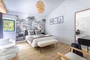 a white bedroom with a bed and a chair at Gite De La Borie in Saint-Ignat
