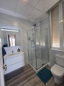 a bathroom with a shower and a toilet and a sink at Hotel La Oficina in San Miguel de Salinas