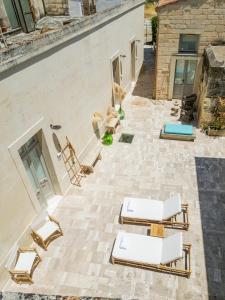 an outdoor patio with lounge chairs and tables at Borgo delle Dimore in Maglie