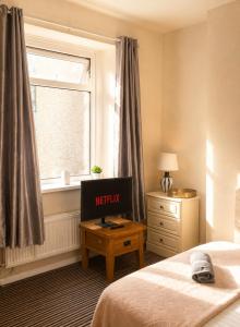 a bedroom with a bed and a desk and a window at 52 - room 2 - smart TV in Swansea