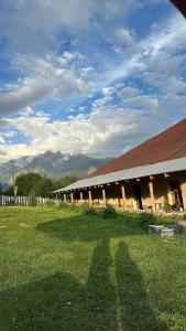 a large building with a red roof in a field at Guesthouse Tetnuldi in Kʼolashi