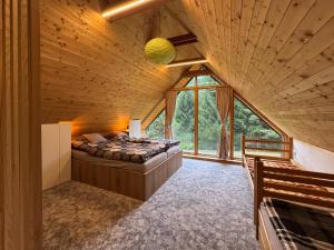 a large bedroom with a bed in a wooden ceiling at Chata Pod Dubem Kameňák in Moravany