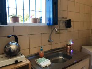 a kitchen counter with a sink with a pot on it at Canto Alegre Pernambuco in Goiana +21 photos
