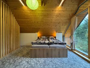 a bedroom with a large bed in a wooden room at Chata Pod Dubem Kameňák in Moravany