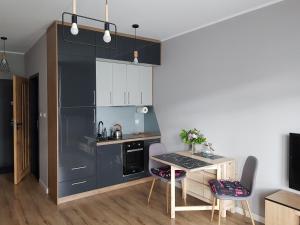 a kitchen with a table and chairs in a room at MazuryTime in Mrągowo