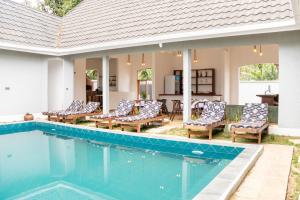 a swimming pool with chairs and a house at Olarashii River Lodge in Arusha