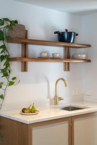 a kitchen with wooden shelves and a sink at Noemia Skiathos in Skiathos +92 photos