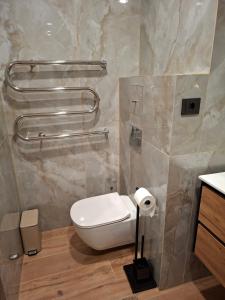 a bathroom with a toilet and two towel bars at Atokvėpis sielai in Šilutė +9 photos
