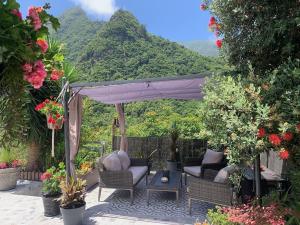 a patio with a couch and chairs and flowers at maderedocevida in Boaventura