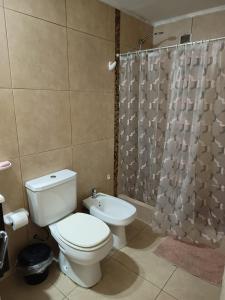 a bathroom with a toilet and a shower curtain at Mi Refugio Venado in Venado Tuerto