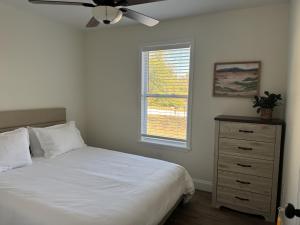 a bedroom with a bed with a ceiling fan and a dresser at Charming Room in Martinez in Martinez