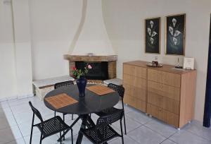 a dining room with a table and chairs and a fireplace at Seven Plus in Filiatra