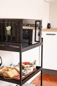 a microwave oven on a stand in a kitchen at Savian Apartment in Savigliano