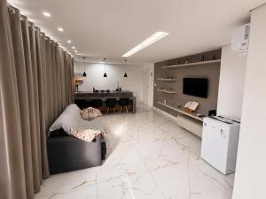 a living room with a couch and a kitchen at Aconchego de Lugar - Eri & Douglas - 4 in Belo Horizonte