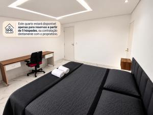a bedroom with a bed and a desk and a computer at Aconchego de Lugar - Eri & Douglas - 4 in Belo Horizonte