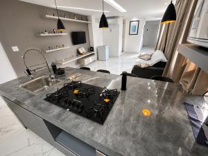 a kitchen with a counter top with a stove top at Aconchego de Lugar - Eri & Douglas - 4 in Belo Horizonte