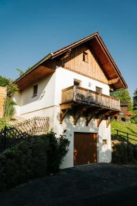 a large white house with a wooden balcony on it at Kellerstöckl Kranach 76 in Gamlitz