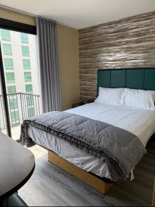 a bedroom with a large bed and a balcony at Skylux Hotel - Long Island City in Queens