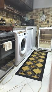 a kitchen with a washing machine and a rug at Hebergement Tamazight 2 in Tarrast