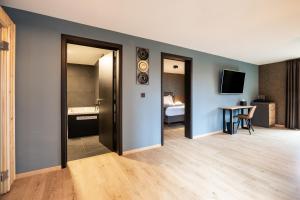 a room with two doors and a room with a bedroom at Hotel & Restaurant Maison Pal'Ange in Durbuy