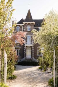 a large brick house with a white door at Historisch herenhuis voor 12 personen met volledig ommuurde tuin in Oudenaarde