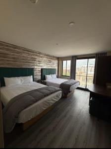 a bedroom with two beds and a large window at Skylux Hotel - Long Island City in Queens